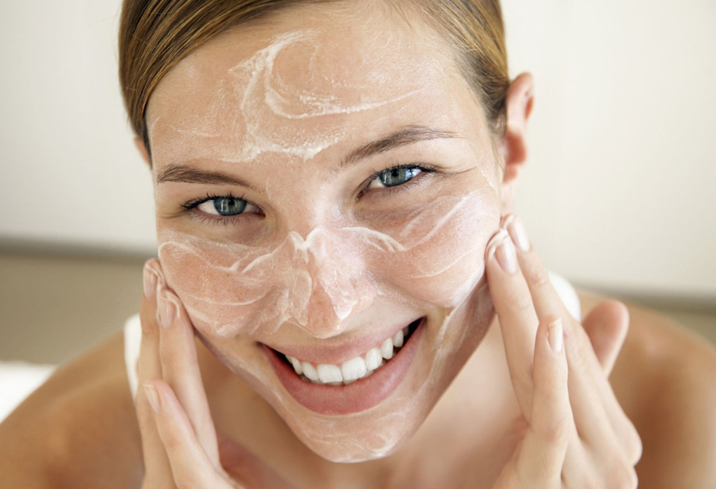 Smiling Young Woman Applying Face Cream